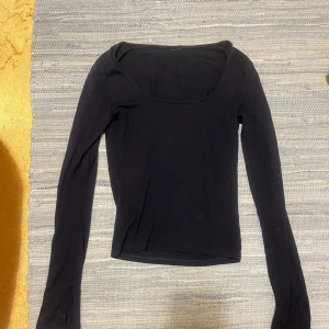 Mörkblå långärmad topp med slits - Säljer en mörkblå långärmad topp med rundad urringning och slits vid ärmslut. Lappen är av men det är storlek XS