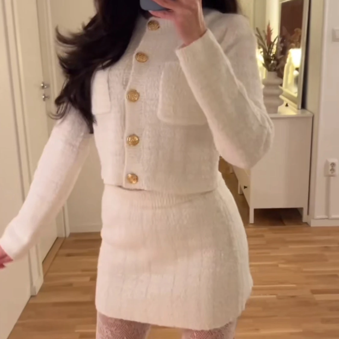 Vit stickad set med guldknappar