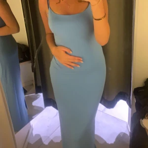 Ljusblå långklänning med smala axelband - En stilren ljusblå långklänning med smala axelband och figurnära passform från BikBok i storlek S. Klänningen har en enkel och elegant design, perfekt för sommarens tillfällen. Näst intill oanvänd och helt utan defekter🥰 