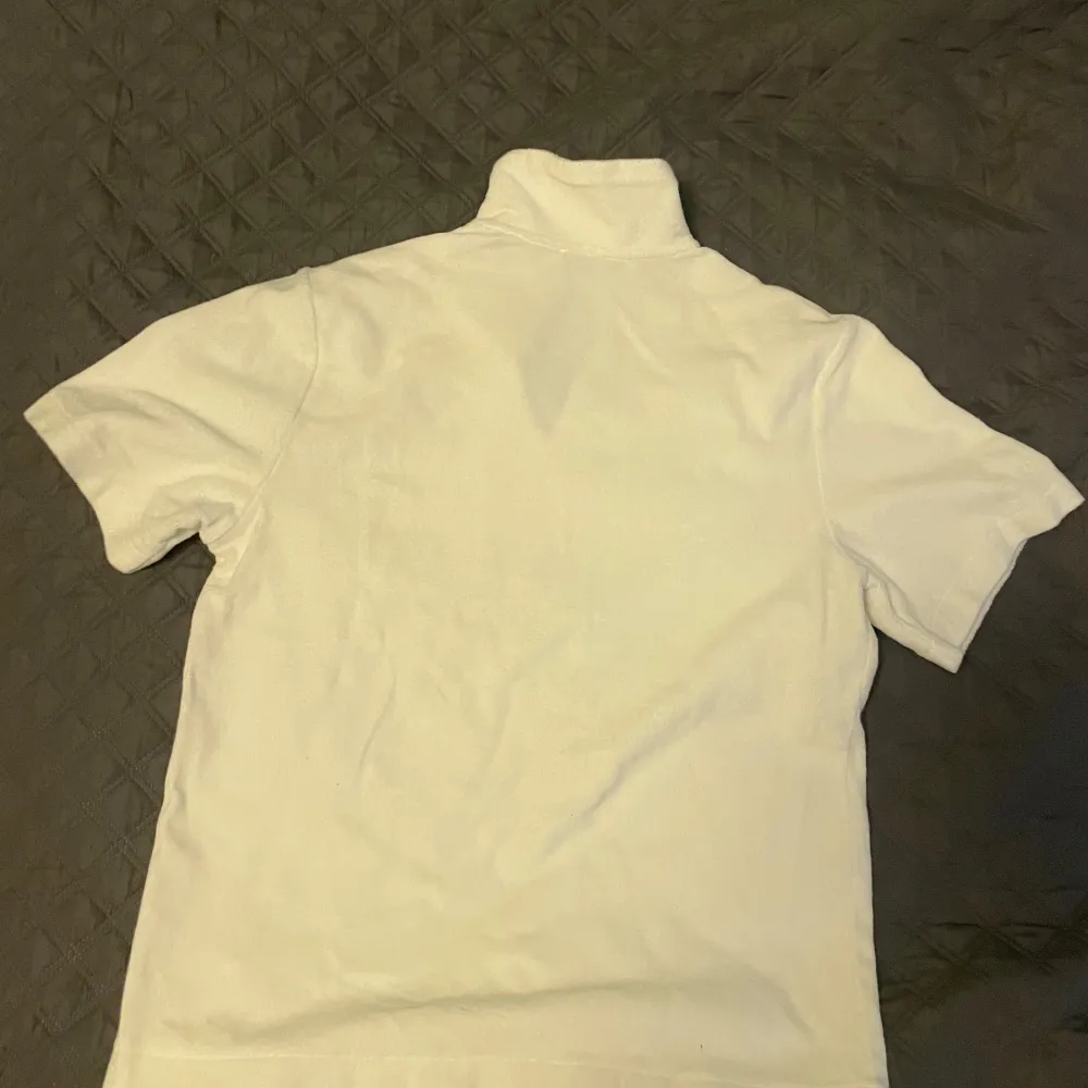 Säljer en vit t-shirt från Whyred med unik krage och bröstficka. T-shirten är i 100% bomull och har korta ärmar. Perfekt för dig som vill ha en stilren och enkel look med en twist. Kontakta för fler bilder🌟. T-paidat.