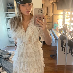 Vit spetsklänning med volanger från By Malina - Super fin studentklänning från by malina🤍 Köpt på plick till min student i år men det blev en annan klänning, ska varit använd en gång, men i nyskick☺️                                  Nypris: 2800 kr.                                     (Mån får även med original kartongen)                                         Kolla gärna min profil då jag har fler vita klänningar det inte blev till min student i år😅 Hör av dig om du har frågor💗