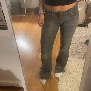 Lågmidjade levis jeans   - Säljer ett par Levis 527 jeans i grå denim med klassisk femficksdesign och bootcut passform. Byxorna har låg midja och subtila slitningar för en cool vintagekänsla. Perfekta för dig som gillar en avslappnad men ändå stilren look. Skeiv för mått eller fler frågor❤️