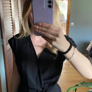 Svart blus  - Säljer en svart blus/topp från Zara. Blusen har korta ärmar och en v-ringad halsringning. Har använt den ett fåtal gånger, men den är helt som ny utan prislappen kvar!