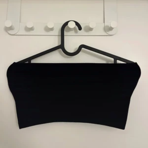 Svart ribbad tubtopp från Zara - Säljer en svart ribbad tubtopp från Zara. Enkel och stilren design som passar perfekt till många olika outfits. Toppen är ärmlös och har en tight passform. Perfekt basplagg i garderoben!