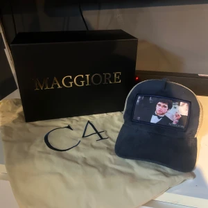 Marinblå och beige keps från Maggiore - Cool blå keps från Maggiore med beige mesh på sidorna och baksidan. Framtill finns en patch med ett tryck av en känd filmscen. Nypris 800 