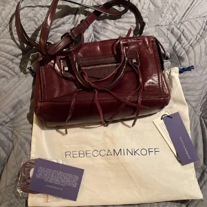 Vinröd väska - Snygg vinröd väska från Rebeccaminkoff💗💗storleken är mellanstor💗(inte min bild)