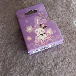 Lila tejp med kaninmotiv - Söt lila tejp med ett gulligt kaninmotiv och blommor på förpackningen. Perfekt för att skapa skarpa linjer vid sminkning, t.ex. eyeliner eller ögonskugga. Kommer i en liten ask med japansk-inspirerad design.