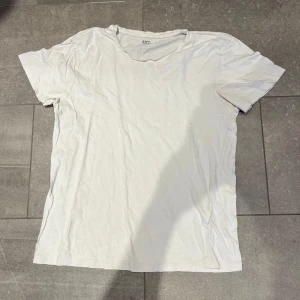 Vit basic t-shirt - En enkel vit t-shirt med rund hals och korta ärmar. Perfekt för en clean och avslappnad stil. Gjord i mjukt material som känns skönt mot huden.