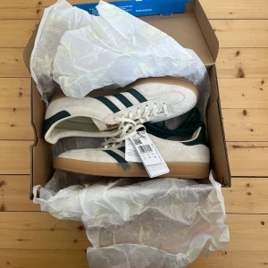 Adidas Gazelle vita /beiga och gröna sneakers - Adidas Gazelle vit/beige gröna Aldrig använda, kommer i original kartong och lappen sitter kvar. Gröna snören kommer med. Nypris ca 850