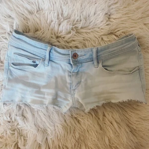 Lågmidjade ljusblåa jeanshorts - Se profil för massa flera jeanshorts!!💞Midja rakt över: ca 38,5+stretch💞(pytteliten defekt, se sista bild)