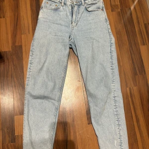 Ljusblå jeans från Weekday - Säljer ett par klassiska ljusblå jeans från Weekday i storlek L, midjemått W28 L30. Byxorna har raka ben, fem fickor och hög midja. Perfekta för en avslappnad och stilren look. Mycket fint skick. Säljes då de är för stora för mig. 