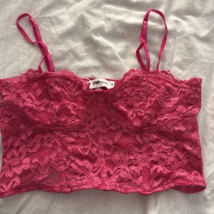 Rosa spetsig croppad linnetopp  - Säljer en snygg rosa croppad linnetopp från Sister S med tunna axelband och vacker spets över hela toppen. Perfekt för att lyfta vilken outfit som helst med sin feminina och trendiga look t.ex under en vit eller svart kavaj!🤩🩷