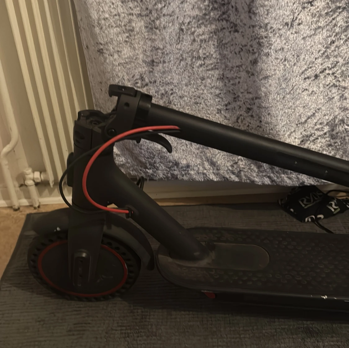 Svart elscooter med röda detaljer