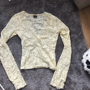 Gul spetsblus med omlott - Säljer en ljusgul tröja,V-uringning. Knappt använd.