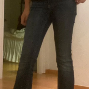 Blå bootcut jeans från Perfect Jeans - Snygga blå bootcut jeans från Gina tricot med klassisk femficksdesign och coola bakfickor med lock och knapp. Jeansen har en lätt tvättad look och sitter riktigt bra i midjan. Perfekta till sneakers eller boots för en avslappnad vibe.