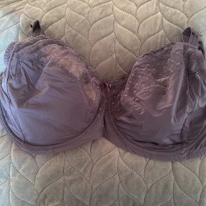 Blå bh med spetsdetaljer 75M - Säljer en blå med bredda axelband och fina spetsdetaljer upptill. Bh har små prickar i spetsen och en söt rosett mellan kuporna. Justerbara axelband och hakknäppning bak för perfekt passform.