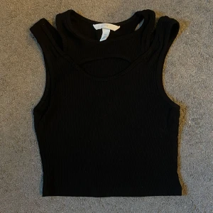 Svart croptop linne - Svart linne som är croppat med liten ”öppning” där fram. Storlek S. Säljer pga för liten storlek. Använd några gånger. Väldigt skönt material och inga sömmar som stör. Första bilden är hur färgen ser ut i verkligheten.