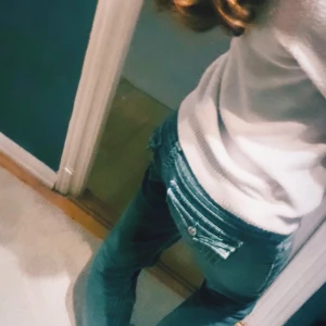 True Religion bootcut jeans grå - Säljer ett par gröna jeans från True Religion med tydliga kontrastsömmar och snygga fickdetaljer bak. Klassisk femficksmodell med låg midja och logga på bakfickan. Midja: 39cm Innerben: 81cm