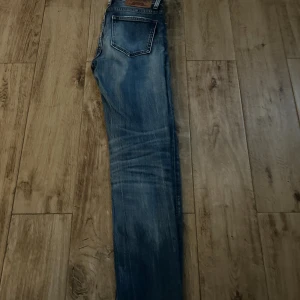 Blå skinny jeans 26/32 - Snygga blå skinny jeans med slitningar och tvättade detaljer. Klassisk femficksmodell och normalhög midja. Perfekta till sneakers eller boots och passar till många olika stilar.