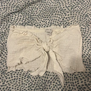 En vit topp  - Jag säljer denna söta croppade toppen. Framme är den knuten passar perfekt med en jeanskjol 