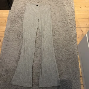 Grå  byxor i mjukt tyg - Snygga grå byxor med hög midja. De är gjorda i ett mjukt och stretchigt material som sitter skönt på kroppen. Perfekta för en chill och trendig look.