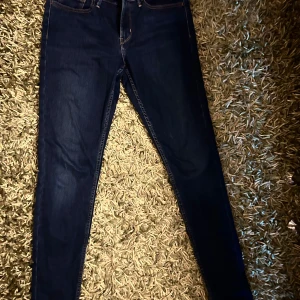 Levi's 710 Super Skinny jeans blå W28 - Mörkblå Levi's 710 Super Skinny jeans med klassiska bakfickor och orange sömmar. Superslimmad passform och stretchigt jeanstyg som sitter tajt hela vägen ner. Perfekta för dig som gillar en riktigt skinny look.