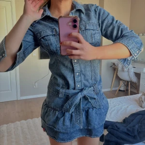 Jeansklänning med volangkjol - Så fin unik jeans klänning köpt second hand men i nyskick. Har volanger i kjolen och är ganska kort. Så unik! 