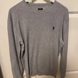 Polo Ralph Lauren tröja - Snygg grå tröja från Polo Ralph Lauren i slim fit-modell. Tröjan är knappt använd och i ett fantastiskt skick. Tröjan är i storlek S men passar även M. Bara höra av dig vid minsta fundering! 😇💯