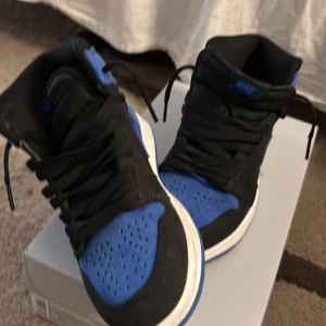 Nike Jordan 1 High blå och svarta - Säljer ett par Nike Jordan 1 High i mocha. Köpt från footlockers inte använda mycket 1-2 gånger riktigt bekväma och fina kommer med blå snören också så man kan välja vilken färg svart eller blå storlek 37,5