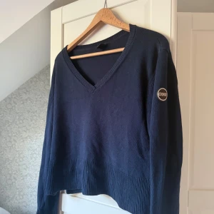 Colmar tröja stickad  - Mörkblå stickad tröja från Colmar med v-ringning och ribbade muddar med slit! Kommer inte till användning 💞