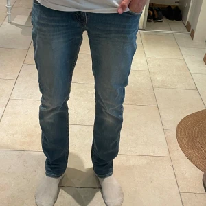 Tiger of Sweden jeans blå 29/32 - Snygga blå jeans från Tiger of Sweden, modell Iggy. Klassisk femficksdesign med raka ben och diskret slitning framtill. Jeansen har normal passform och är tillverkade i mjukt denimtyg. Perfekta för dig som gillar stilrena och tidlösa jeans. Höst och vinter