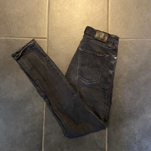 Nudie Jeans - Säljer ett par klassiska Nudie jeans. Den grå/ svarta färgen gör dem otroligt mångsidiga – passar lika bra till en avslappnad dag som till en utekväll.  Storlek: W28 L32  |   Skick: 9/10  |   Passform: Slim fit   Hör av dig vid minsta fundering eller intresse! Skickar gärna fler bilder om det önskas!
