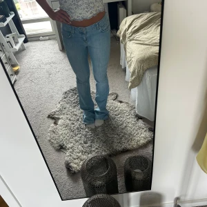 Ljusblå bootcut jeans - Säljer ett par ljusblå jeans med bootcut-modell och klassisk femficksdesign. Jeansen har normal passform och är tillverkade i bomull. Perfekta för dig som gillar en avslappnad men ändå snygg stil.