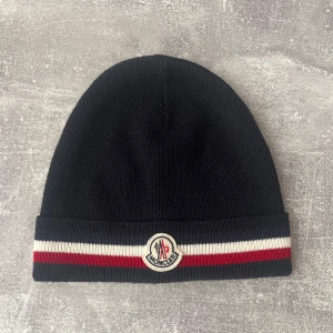 Moncler mössa - Säljer en marinblå Moncler mössa. Väldigt fint skick och snygg design. 