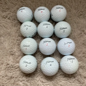 Fina golfbollar - Bilderna visar flera golfbollar av märket Titleist, men ingen bok. Om du letar efter sportutrustning är dessa golfbollar perfekta för dig som vill förbättra ditt spel på banan.