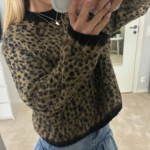 Leopardmönstrad stickad tröja - Supermjuk stickad tröja med leopardmönster i brun och svart. Tröjan har svarta muddar vid hals, ärmslut och nederkant. Storlek xs men sitter som s🥰pris kan diskuteras!