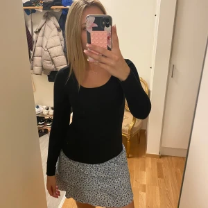 Svart långärmad topp med rund hals - En svart, tight långärmad topp med rundad halsringning. Enkel och stilren modell som sitter figurnära och passar perfekt till både jeans och kjol. Mjuk och stretchig känsla, perfekt för lager-på-lager eller som den är.