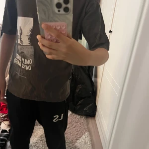 Grå t-shirt med tryck - Cool grå t-shirt med vit grafisk print framtill som visar en cyklist och texten 'ONLY COOL DAYS AHEAD'. T-shirten har klassisk passform och korta ärmar. Perfekt för dig som gillar streetstyle och vill ha en avslappnad look.