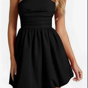 Svart axelbandslös kort klänning - Supersnygg svart axelbandslös kort klänning med markerad midja och utställd kjol. Perfekt för dig som vill ha en stilren och klassisk look. Enkel design som ändå känns riktigt trendig.