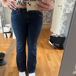 Mörkblå bootcut jeans - Säljer ett par mörkblå jeans med bootcut-modell och klassiska fickor både fram och bak. Jeansen har låg midja och snygga kontrastsömmar på bakfickorna. Köpta från hm i storlek 40 men sitter mer som 38. Pris kan diskuteras!