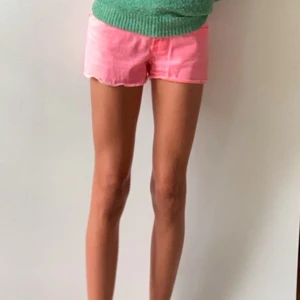 Rosa jeansshorts med snygga detaljer  - Snygga ljusrosa jeansshorts med låg midja. Shortsen har tre knappar framtill, snygga fickor både fram och bak. Perfekta för sommardagar. Mycket fåtal gånger använd. Plus man ser mycket brun ut i den. Pris kan även diskuteras💕