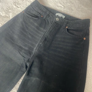 Svarta raka jeans från H&M - Snygga svarta jeans från H&M med raka ben och klassisk femficksdesign. Hög midja och stilren look som passar till allt. Jeansen är i ett mjukt bomullsmaterial med lite stretch för extra komfort.