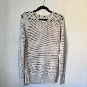 Beige stickad tröja från Lindex - Snygg beige stickad tröja från Lindex med grovt nätmönster. Långärmad modell med ribbade muddar vid ärmslut och nederkant. Perfekt för lager-på-lager och ger en chill vibe till din outfit.