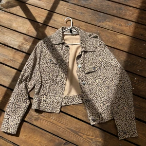 Leopardmönstrad jeansjacka beige - Säljer en beige jeansjacka med leopardmönster och silvriga knappar. Jackan är croppad med klassisk krage och två bröstfickor med lock. Jättefint sommarplagg. Perfekt statement-plagg för dig som vill sticka ut lite extra. 🐆❤️‍🔥