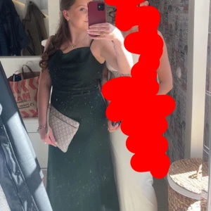 Mörkgrön långklänning - Säljer en elegant mörkgrön långklänning med öppen rygg och med siden material. Jag säljer klänningen eftersom den inte kommer till användning. Använd bara en gång på lärarmiddag. Utsprungspris 1100kr från bubbleroom.💞💞