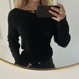 Svart stickad tröja med öppen rygg NA-KD - Svart stickad tröja från NA-KD i storlek XS. Tröjan har lång ärm, twistad detalj bak och en djup öppen rygg som ger en snygg och unik look 😍🥰