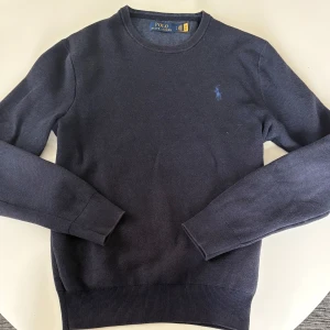 Polo Ralph Lauren Crewneck Sweater - Den här klassiska rundhalsade tröjan är gjord av en mjuk bomullsblend. Den har en avslappnad passform och en liten Polo Ralph Lauren-logotyp på bröstet | Skick: 8/10 Sparsamt använd | Nypris: 2400kr - Mitt pris 550kr | Storlek: S | Färg: Navy Heather | Hör av dig vid funderingar 📩