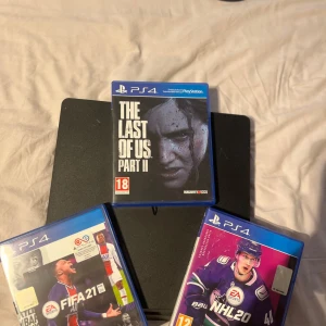PS4 med spel, kablar och trådlös laddare - Till salu: PS4 med spel, kablar och trådlös laddare – Komplett paket (utan handkontroll)  Säljer en fullt fungerande PlayStation 4 i bra skick. Perfekt för dig som redan har handkontroll och vill utöka med ett komplett set med spel!  Ingår i paketet: 	•	PlayStation 4 (PS4)  	•	Originalkablar (ström och HDMI) 	•	Trådlös laddare 	•	3 populära spel: 🎮 The Last of Us Part II ⚽ FIFA 21 🏒 NHL 20  Observera: Ingen handkontroll ingår.  Konsolen är fabriksåterställd och redo för användning.