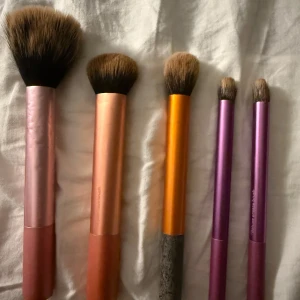 Set med Real Techniques sminkborstar - Fem sminkborstar från Real Techniques i olika storlekar och former. Perfekta för bas, contour och ögonskuggor. Snygg design och lätta att använda för både ansikte och ögon. Dessa borstar kommer att rengöras innan jag skickar de. 