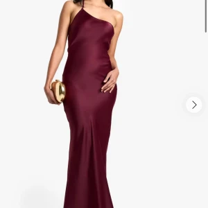 Vinröd långklänning med oneshoulder - Klänning från boohoo                                                         Prislapp kvar aldrig använd.                                                                                                     Stl 42 men skulle säga lite minder